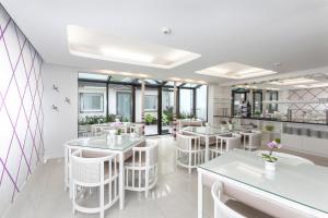 デュッセルドルフにあるホテル プリンツ アントンの白いテーブルと白い椅子が備わるレストラン