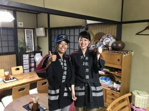 dos personas dando los pulgares en una habitación en Kakure-Yado Yuji-inn, en Kurashiki