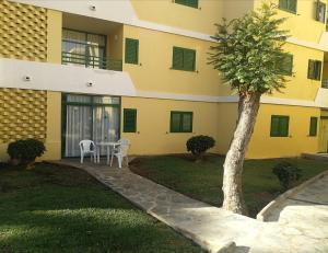 un edificio con una mesa y un árbol en el patio en Huella Canaria, en Playa del Inglés