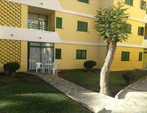a building with a table and a tree in the yard at Huella Canaria in Playa del Ingles