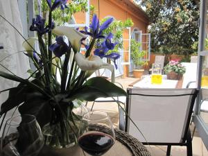 a table with a vase of flowers and a glass of wine at Vivelorural casa El Gargujo con piscina in Santa Brígida