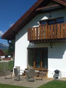 a patio with chairs and a deck with a grill at Apartmány Máša in Liptovský Trnovec