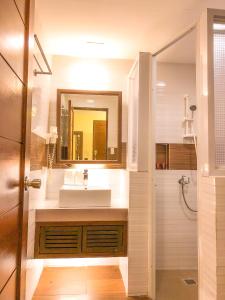 a bathroom with a sink, mirror, and bathtub at The Piccolo Hotel of Boracay in Boracay