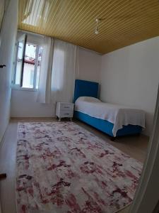 a bedroom with a bed and a rug and a window at Demir Apart Otel in Kaş