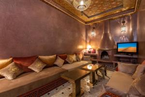 a living room with a couch and a fireplace at Riad AZARO in Marrakesh