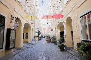 alejka z parasolami wiszącymi na budynkach w obiekcie HeyMi Apartments Stadtpark w Wiedniu
