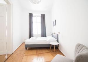 biała sypialnia z łóżkiem i stołem w obiekcie HeyMi Apartments Stadtpark w Wiedniu