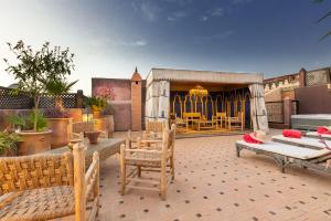 a patio with chairs and tables and a building at Riad AZARO in Marrakesh