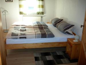 a bedroom with a wooden bed with pillows on it at Ferienwohnung Deuerling in Nurn