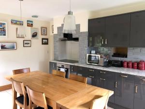 una cucina con tavolo in legno e forno a microonde di Lazy Daze Cottage a Horsham Altre 10 foto