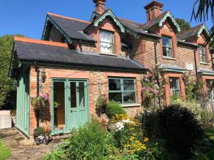 una vecchia casa in mattoni con porta verde di Lazy Daze Cottage a Horsham