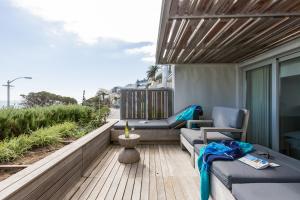 a balcony with two chairs and a couch and a table at Waters Edge 101 in Cape Town
