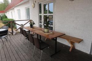 einen Holztisch und Stühle auf einer Terrasse in der Unterkunft Burning Bridge Motell & Vandrarhem in Götene