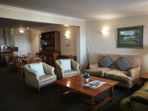 a living room with a couch and chairs and a table at Zevenwacht Cottages in Kuilsrivier