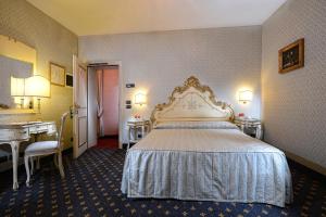 a hotel room with a large bed and a desk at Cà Rialto in Venice