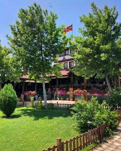 una casa con una valla y árboles en un patio en Etno Selo Timcevski Complex, en Kumanovo