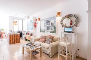 a living room with a couch and a mirror at Apartamentos Ros in Santa Eularia des Riu