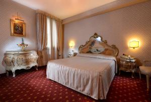 a hotel room with a bed and two tables at Cà Rialto in Venice