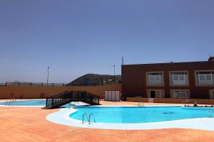 a large swimming pool in front of a building at Casa Idilica Apartment in Corralejo