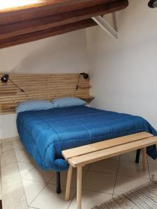 a bed with a wooden headboard and a bench at la casetta nel cortile in Catania