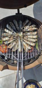 a basket of fish cooking on a grill at MAISON D’HÔTE LES TORTUES - in Al Hoceïma