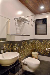 a bathroom with a white toilet and a sink at Hotel Grand Ecotel, Aurangabad in Aurangabad