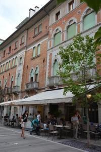 a group of people sitting at tables in front of a building at EXCELSIOR 10 - Luxury apartment in Grado