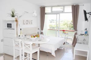 un comedor blanco con una mesa y sillas blancas en Edificio Las Marañuelas, Puerto La Cruz, Islas Canarias Tenerife, en Puerto de la Cruz