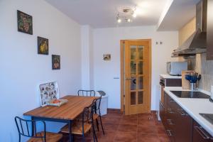 a kitchen with a wooden table and a dining room at Casa Idilica Apartment in Corralejo