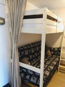 a white bunk bed with a couch in a room at La Corneille Blanche in Les Deux Alpes