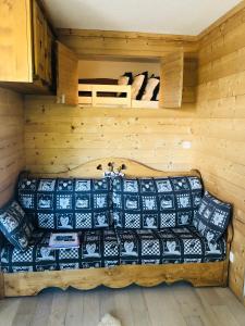 una sala de estar con sofá en una cabaña en La Corneille Blanche, en Les Deux Alpes