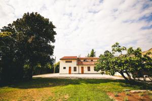 una grande casa bianca con alberi di fronte di Fuoricittà a Povegliano Veronese