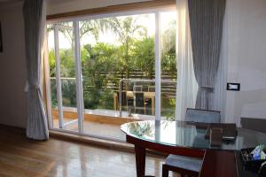 a living room with a glass table and a large window at 7 Seasons resort & Spa in Jamnagar