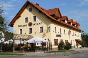 un gran edificio blanco con un cartel. en Hotel Gasthaus Sonne en Peißenberg