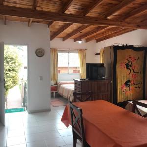 Una habitación con dos camas y un televisor y una mesa. en Departamento Con Vistas a La Montaña, en Villa Carlos Paz