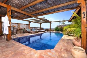 an outdoor swimming pool with a wooden pergola at אניצ'ה in Had Nes