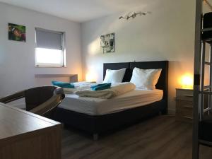 a bedroom with a large bed with white sheets and blue pillows at Gretel von Birne in Winterberg