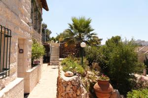 a garden with flowers and a building with a staircase at Jerusalem Mansion in Jerusalem