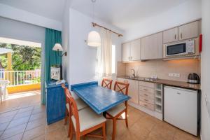 a kitchen with a table and chairs in a room at Comitas Isla del Aire in Punta Prima