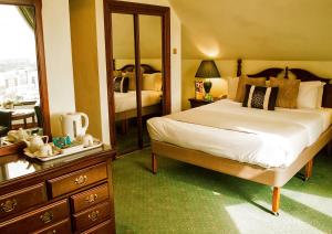 1 dormitorio con cama, tocador y espejo en Britannia International Hotel Canary Wharf, en Londres