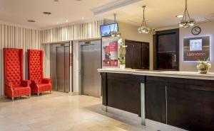 a kitchen with a red chair and a red refrigerator at Leonardo Hotel Budapest in Budapest