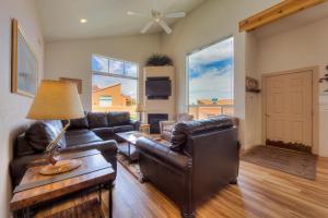 a living room with leather furniture and large windows at Rim Village I4 in Moab