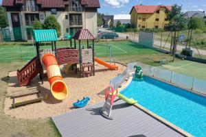 een speeltuin met een glijbaan en een zwembad bij Hotel SPA Activia in Jastrzębia Góra