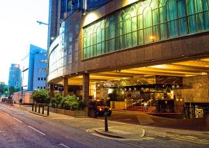 ein großes Gebäude in der Nacht auf einer Stadtstraße in der Unterkunft Britannia International Hotel Canary Wharf in London