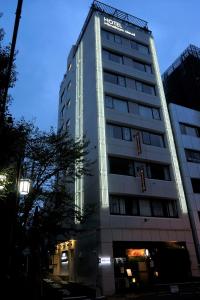 Un palazzo alto con un cartello sul lato. di Himalaya Cloud Hotel a Tokyo