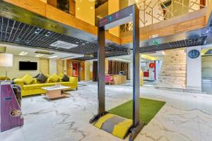 a room with a lobby with yellow furniture at Staybook Hotel Nitya Maharani in New Delhi