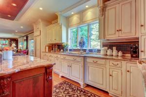a large kitchen with white cabinets and a large island at Grandeur On The Green in Kennebunkport