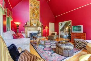 a living room with red walls and a fireplace at Grandeur On The Green in Kennebunkport