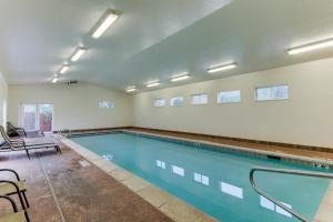 a swimming pool in a room with chairs and a table at Cottonwoods 405 in Moab