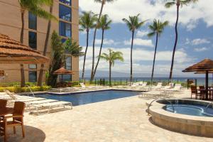 - une piscine avec des chaises longues et des palmiers dans l'établissement Mahana at Kaanapali 618, à Kaanapali